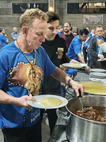 Homem com a camiseta do Terço na fila do jantar