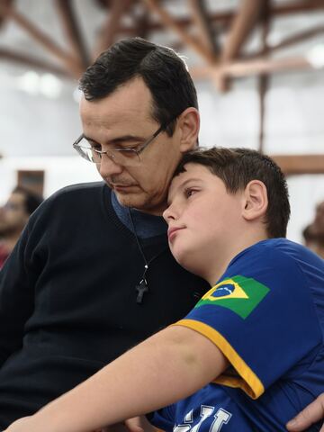 Pai e filho acompanhando o encontro nos bancos