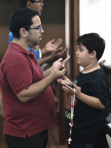 Homem e menino com o terço na igreja