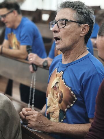Homem com a camiseta do grupo na oração
