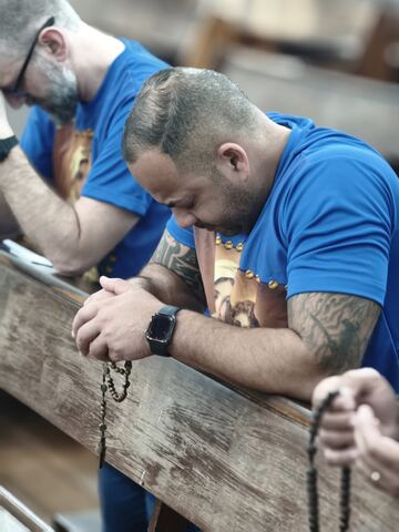 Homem em oração apoiado no banco
