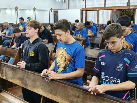 Jovens rezando o terço nos bancos
