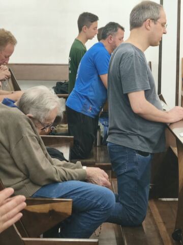 Grupo em oração nos bancos da igreja