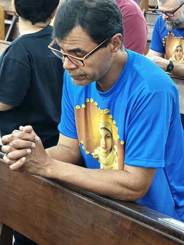 Homem com a camiseta do Terço em oração