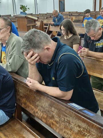 Homens em oração nos bancos da igreja