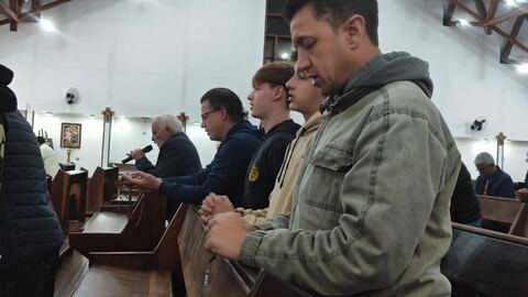 Homens acompanhando a oração do terço