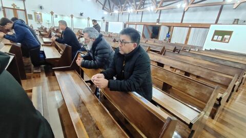 Homens sentados em oração na igreja
