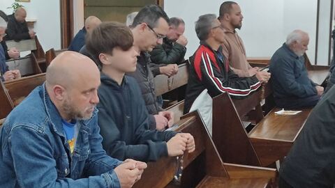 Homens concentrados na oração do terço