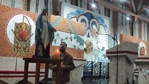 Homem em oração junto à imagem de Nossa Senhora